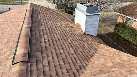 Close-up of new architectural shingles and chimney flashing on a home in Killeen, Texas