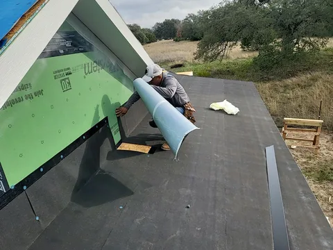 Standing seam metal panels being installed over a porch roof in Georgetown, Texas